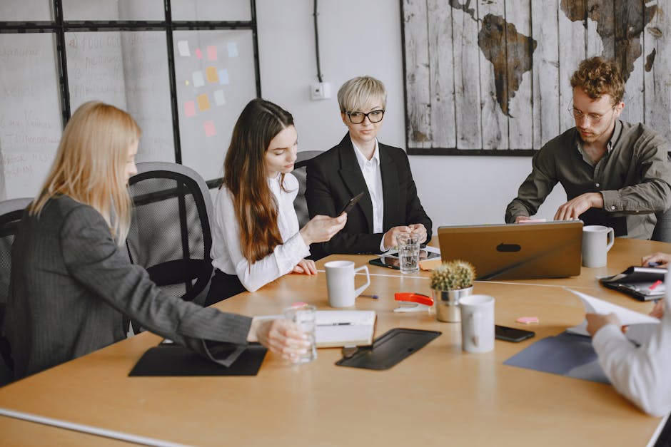 A group of business professionals working together at an office meeting table.